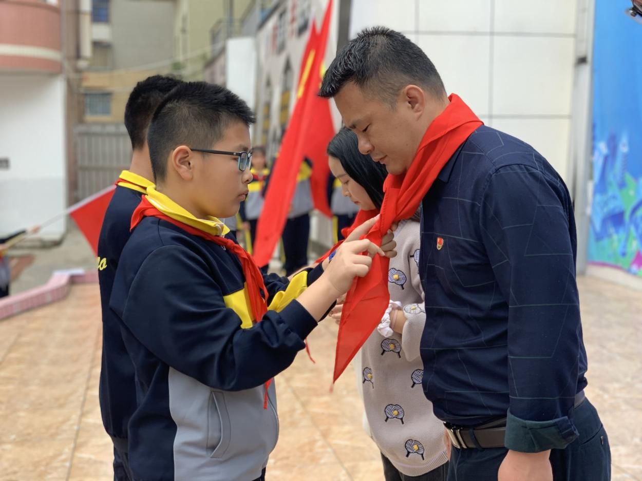 图为少先队员代表为参加活动的领导佩戴红领巾