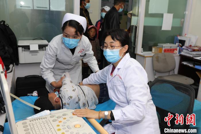 图为首都儿科研究所附属儿童医院医生包敏给孩子做检查.