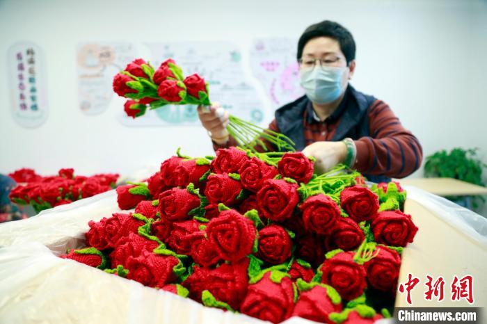 工作人员将编结好的北京冬奥会颁奖花束整理装箱。　汤彦俊 摄