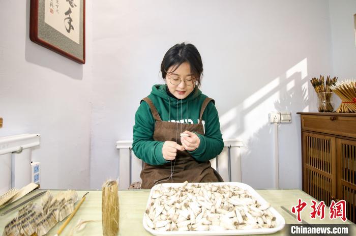 十几道工序后毛笔的笔头初步成型，图为李红玉在捆笔头。　吕明会 摄