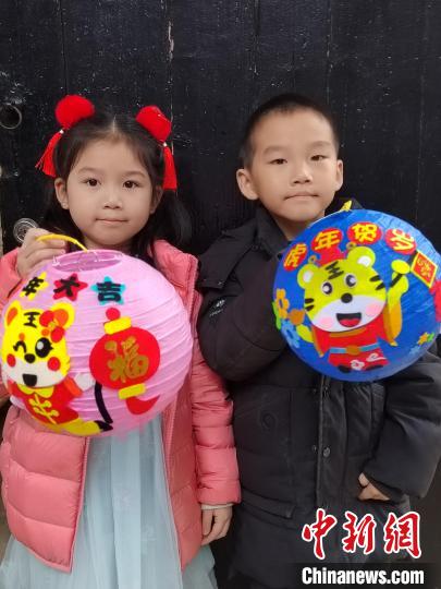 孩子们展示由志愿者辅导制作的虎年灯笼。　翁珊 摄