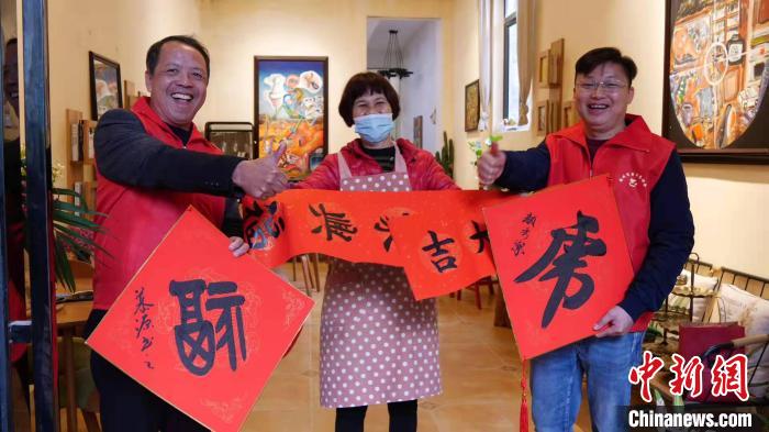 文艺志愿者给市民送春联。　丰韵 摄
