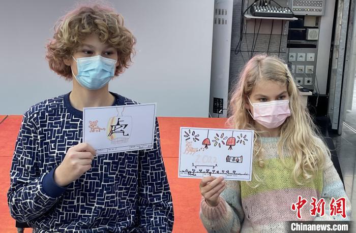 小朋友展示手写手绘的虎年明信片。　德永健 摄
