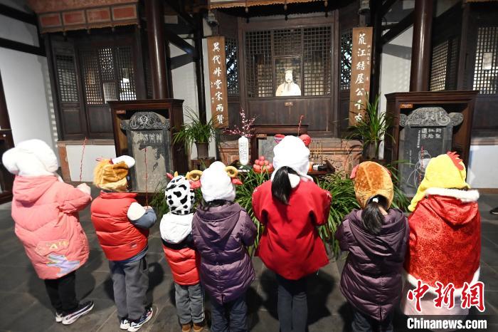 孩童向诗圣杜甫塑像敬献梅枝。　安源 摄