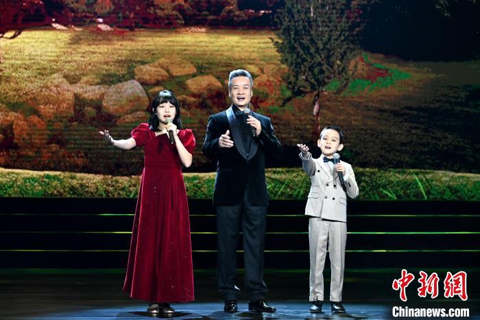 著名歌唱家阎维文(中)和外孙、外孙女在晚会表演现场 中国少年儿童文化艺术基金会供图