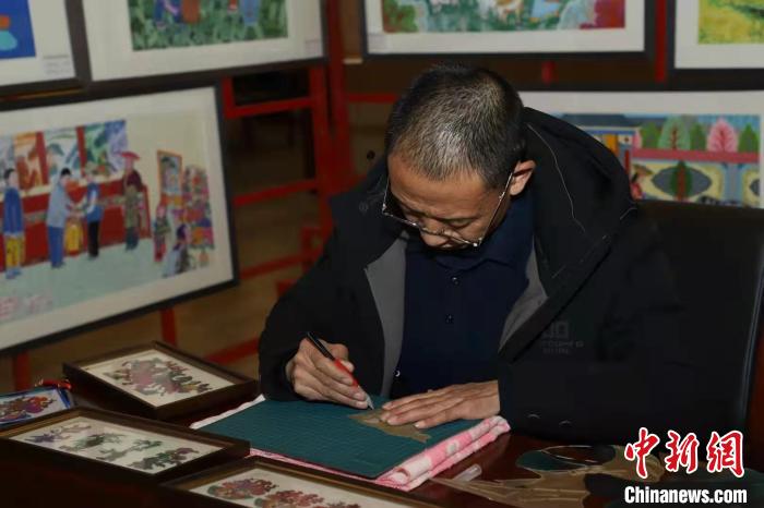 图为靳永红正在雕刻皮影。 受访者供图 图为靳永红正在雕刻皮影。 受访者供图