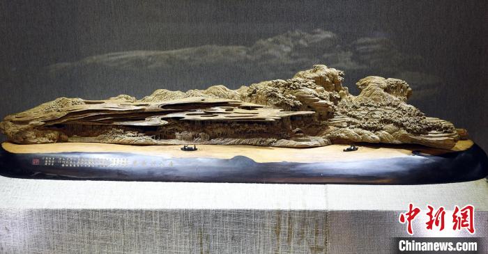 图为中国工艺美术大师郑春辉参展木雕作品《唐人诗意图》。　记者刘可耕 摄