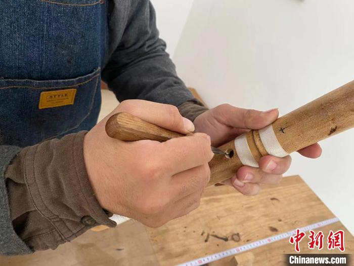 图为曹昊在对尺八进行修孔制作。　赵丹媚 摄